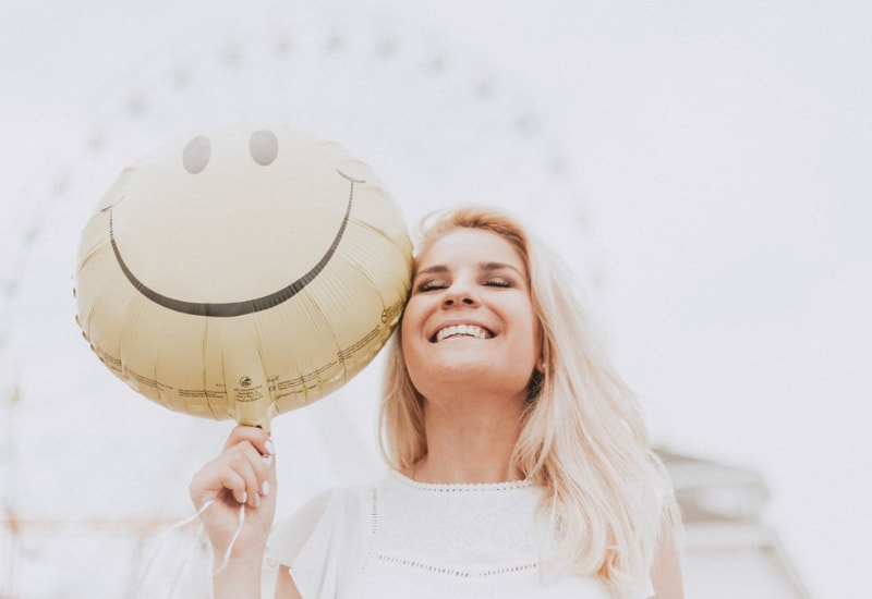woman smiling with a happy face balloon