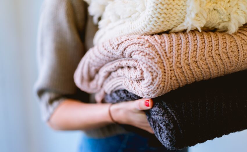 woman holding folded clothes