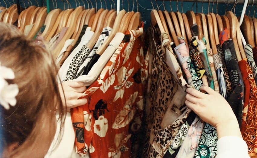 woman looking through a rack of clothes