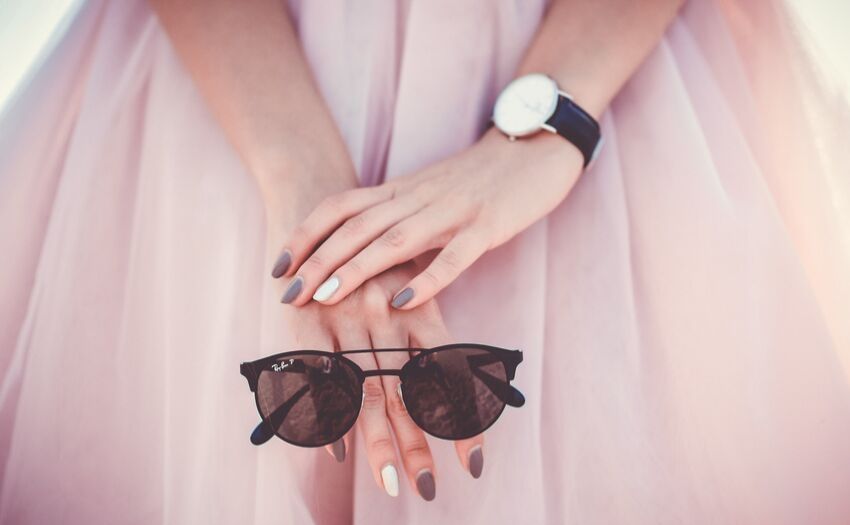 close shot of a woman holding sunglasses in her hands