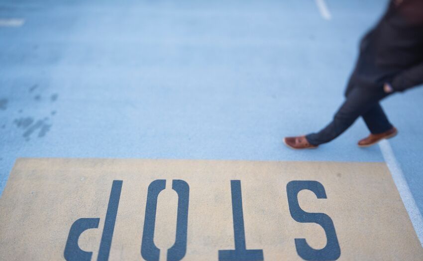 man walking by a stop sign on the ground