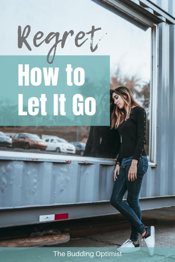 How to get over regret - sad woman standing next to window-min