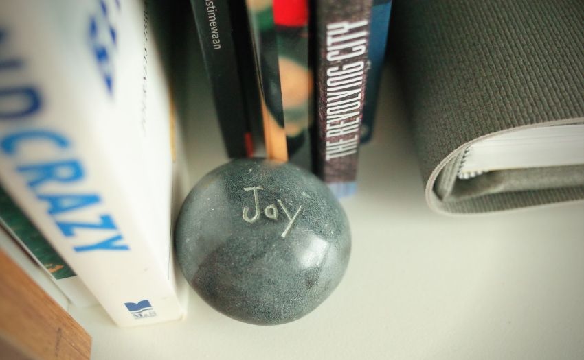 Stone with the word "joy" engraved on it