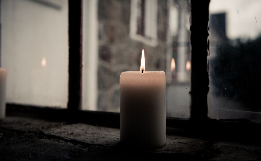 a candle by a dark window