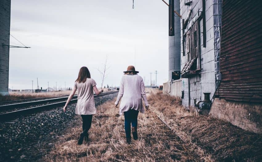 Two women walking on railway