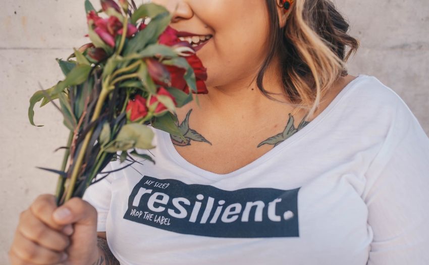 woman wearing a white t-shirt with the word resilient on it