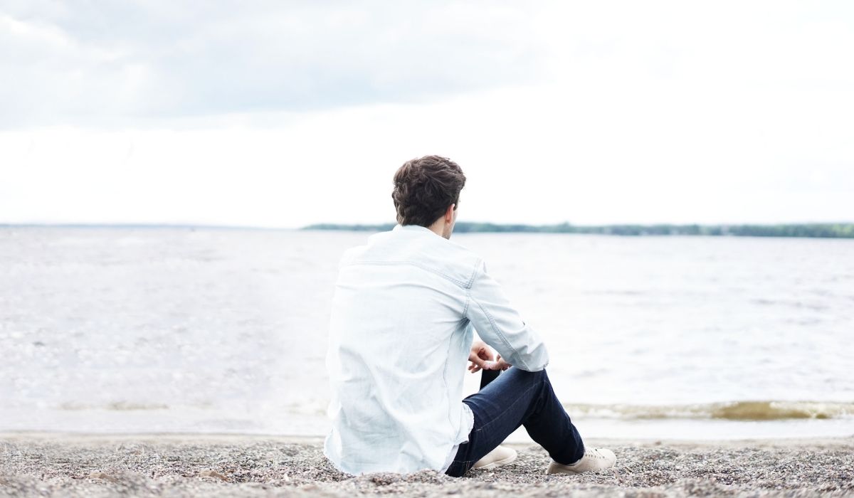 man sitting by himself on the beach