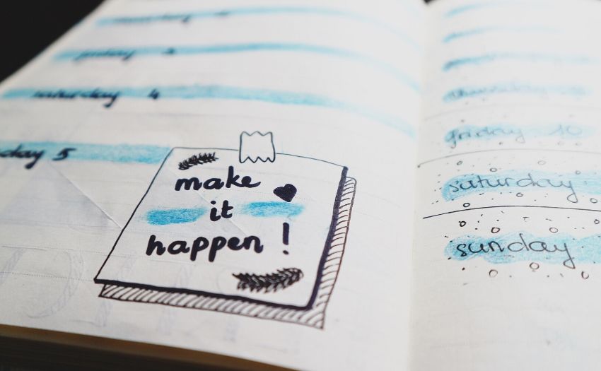 a notebook containing the words make it happen