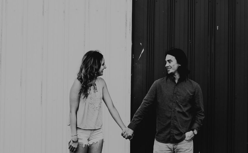 woman and man standing in front of black and white background