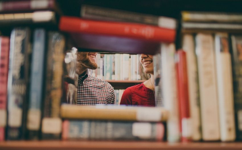 Deep Questions to Ask Feature image man and woman smiling behind books
