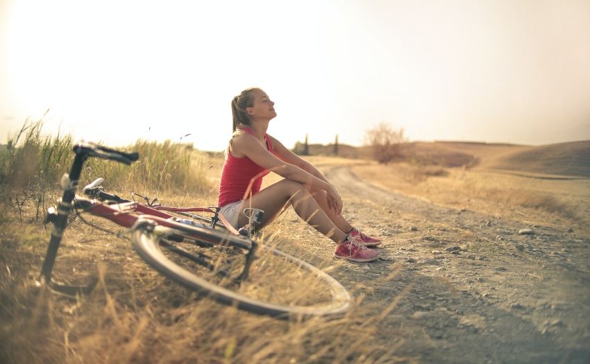 Lung exercises feature image woman sitting down with a bicycle next to her