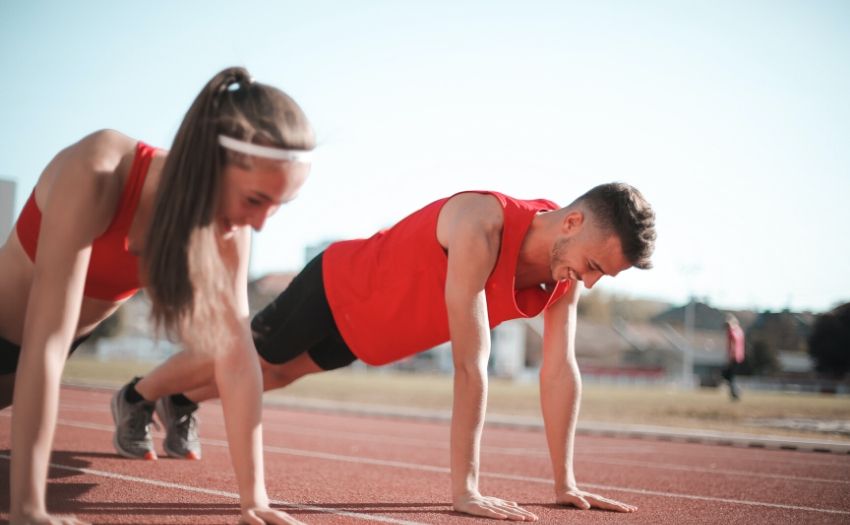 man and woman dressed in red doing push ups