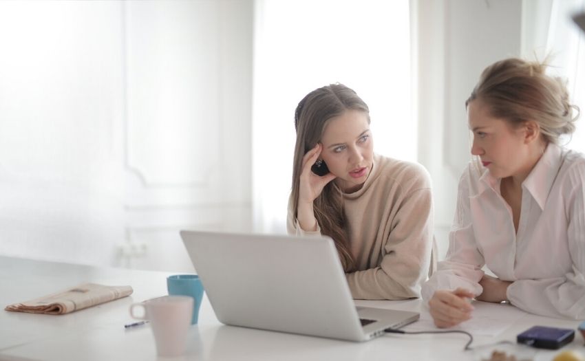 How to deal with difficult coworkers feature image two women talking in front of a laptop