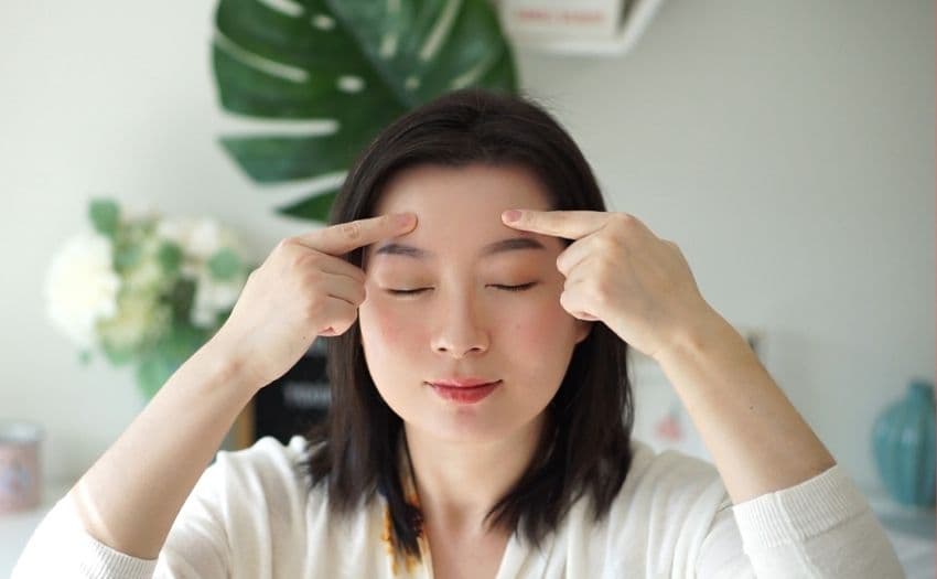 Sabrina demonstrating where to find the Yangbai facial acupressure point